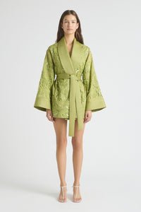 Woman wearing a green embroidered robe on a white background