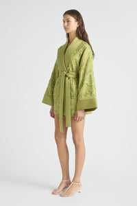 Woman wearing a green textured robe on a white background