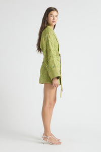 Woman wearing a green lace outfit on a white background
